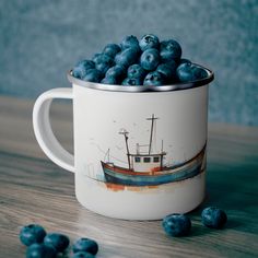 a coffee cup filled with blueberries sitting on top of a wooden table