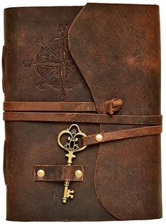 a brown leather journal with an antique key on the front and two keys attached to it