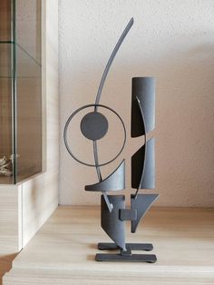 a metal sculpture sitting on top of a wooden table