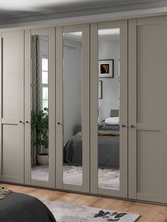 an image of a bedroom setting with mirrors on the doors and closets in it