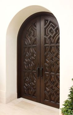 a large wooden door with intricate carvings on it's sides and an arched doorway