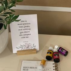 an assortment of essential oils sitting on a table next to a notepad and pen