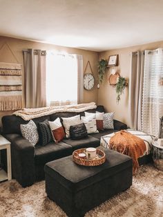 a living room filled with lots of furniture and pillows on top of a brown rug