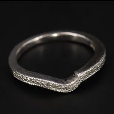 a close up view of a wedding ring with diamonds on it's sides and the band in white gold