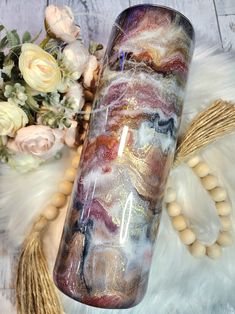 a close up of a glass vase on a table with flowers and other items in the background