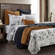 a bed covered in blankets and pillows with animals on them