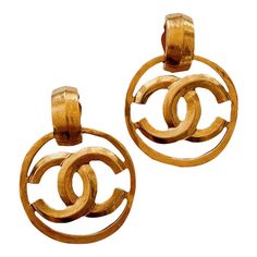 Authentic vintage Chanel circa Spring 1996  In mint vintage condition  24kt matte gold plated hardware  Fold over clip-on backs  Rare statement style  Each measures 2 1/2″ in length by 1 3/4″ across in width Gold Formal Earrings With Gold-tone Logo, Gold Designer Metal Clip-on Earrings, Designer Gold Metal Clip-on Earrings, Classic Gold Clip-on Earrings With Logo Plaque, Luxury Gold Clip-on Earrings With Logo, Chanel Earrings Hoop, Luxury Vintage Clip-on Hoop Earrings, Vintage Gold Clip-on Hoop Earrings, Luxury Oval Vintage Clip-on Earrings