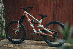 a mountain bike parked in front of a wooden fence