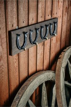 there is a coat rack on the wall next to an old wagon wheel and wheels