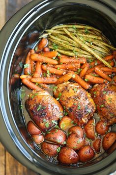 chicken, carrots and asparagus in a crock pot on the stove