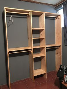 an empty closet with shelves and clothes hanging on hooks