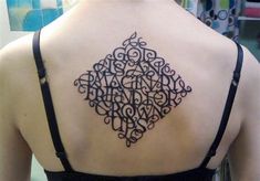 the back of a woman's shoulder with an intricate tattoo design on her upper back