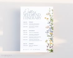 a white wedding weekend itinerary card with wildflowers and greenery on the front