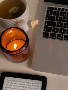 an open laptop computer sitting next to a cup of tea