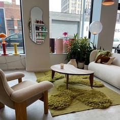 a living room filled with furniture and large windows