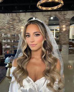 a woman wearing a wedding veil in a salon