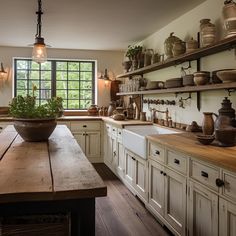 an old fashioned kitchen with lots of pots and pans on the shelf above the sink