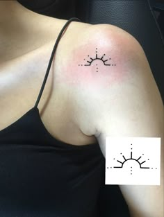 a woman with a tattoo on her shoulder that has the sun and stars in it