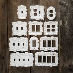 eight pieces of white lace sitting on top of a wooden table