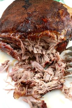 a close up of a plate of food with meat on it and a fork next to it