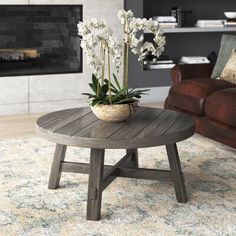 a living room with a couch, chair and coffee table in front of a fireplace