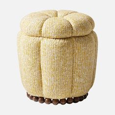 a yellow ottoman with wooden beads on the bottom and an upholstered foot rest