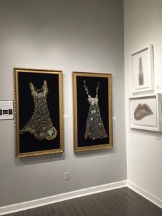 two framed pictures on the wall in an art gallery, one has a dress made out of sequins