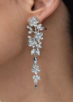 a close up view of a woman's ear wearing earrings with flowers on them