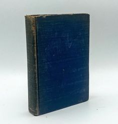 an old blue book sitting on top of a white table