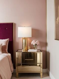 a pink and gold bedroom with two nightstands next to each other on the floor