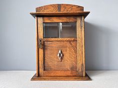 an old fashioned wooden door with glass on the top and bottom panel, in front of a gray wall