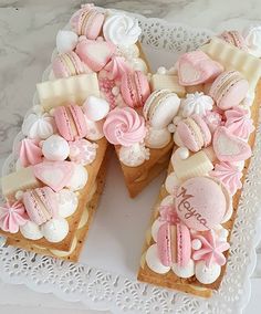 a white plate topped with two slices of cake covered in pink and white frosting