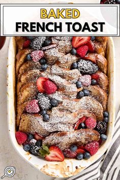 baked french toast with berries and powdered sugar in a white casserole dish