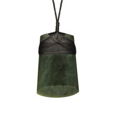 a green and black pendant hanging from a cord