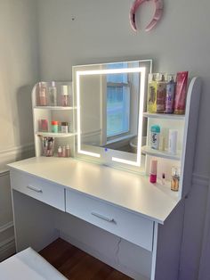 a white desk topped with a mirror and drawers