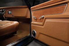 the interior of an old car with leather seats and door handle knobs on it