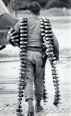 a man walking in the rain with his back to the camera, covered in wooden beads