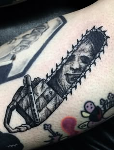 a man with a tattoo on his arm holding a chainsaw