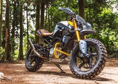 a yellow and black motorcycle parked in the woods