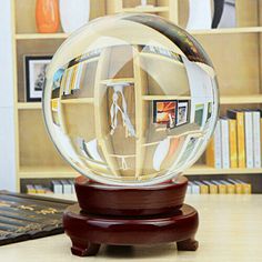 a glass ball sitting on top of a wooden table next to a book shelf filled with books