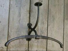 a wrought iron hook on the side of a wooden wall