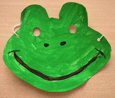 a paper plate with a green frog face on it