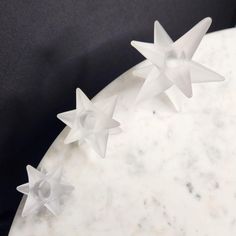 three white plastic stars sitting on top of a marble table