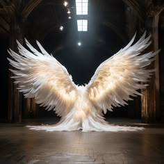 a large white bird with wings spread out in an old building, lit by lights