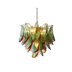 a green chandelier hanging from a chain on a white wall with red and yellow flowers