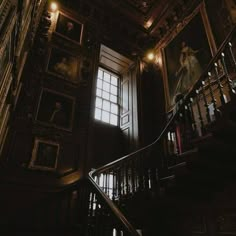 the stairs in an old building are lit up with lights and paintings on the walls