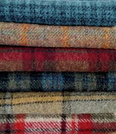 a pile of different colored plaid fabric on top of each other in various sizes and colors