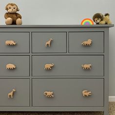 a gray dresser with toy animals on top