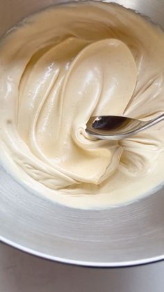 a spoon in a bowl filled with cream