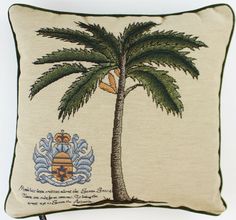 an embroidered pillow with a palm tree and coat of arms